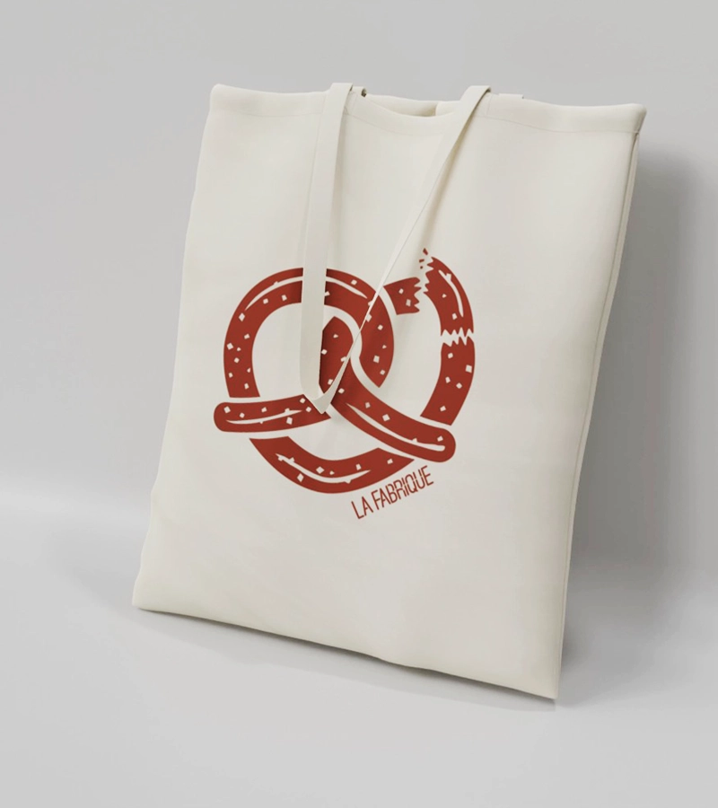 Sac en coton marqué d'un bretzel en forme de coeur et du logo La Fabrique